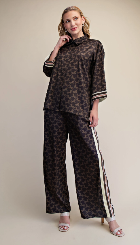 Woman wearing a patterned top and pants with a beige background