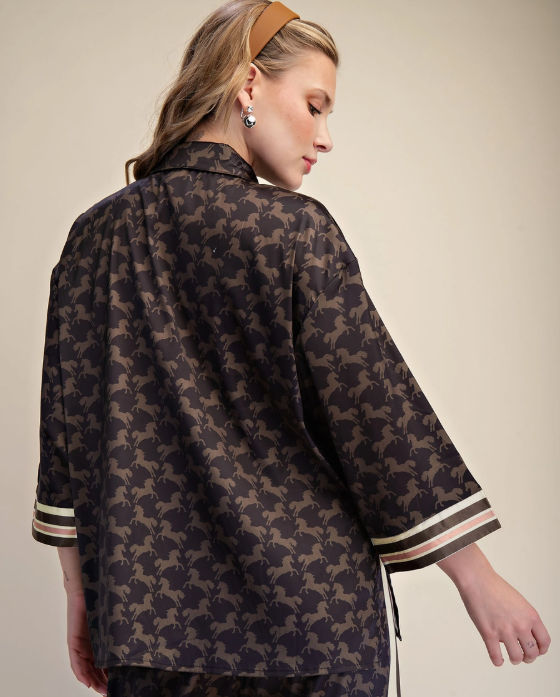 Woman wearing a patterned top with a neutral background