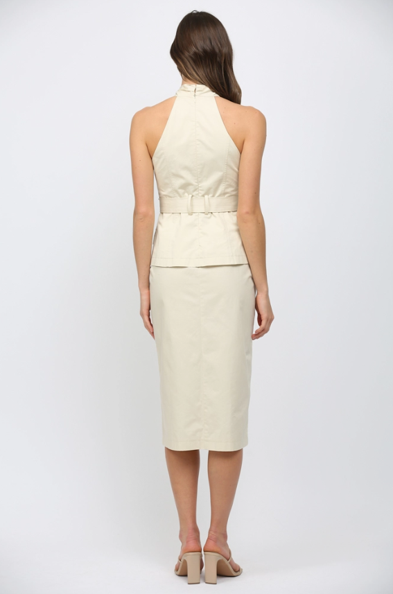 Woman wearing a cream-colored halter top and pencil skirt on a white background