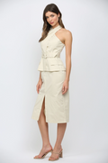 Woman wearing a light-colored dress with a halter top and skirt on a white background